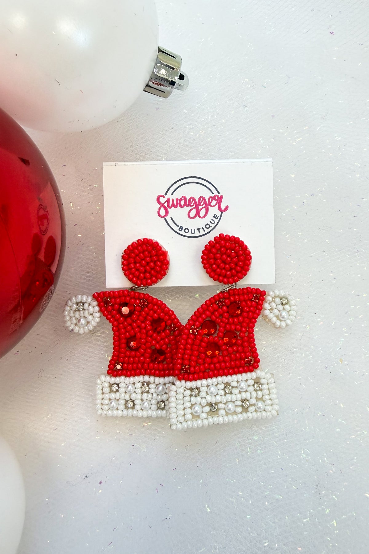 Holiday Spirit Earrings Santa Hat against holiday background.