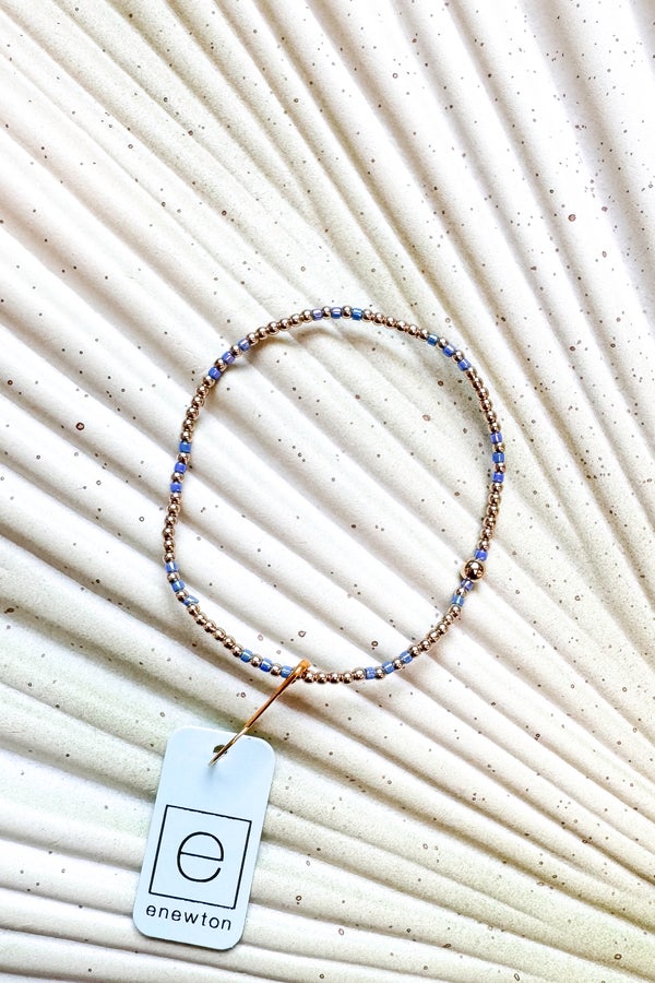 Beaded necklace with a tag on a textured beige background