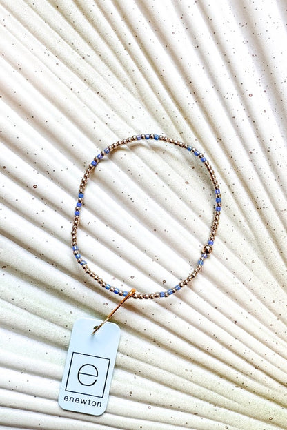 Beaded necklace with a tag on a textured beige background