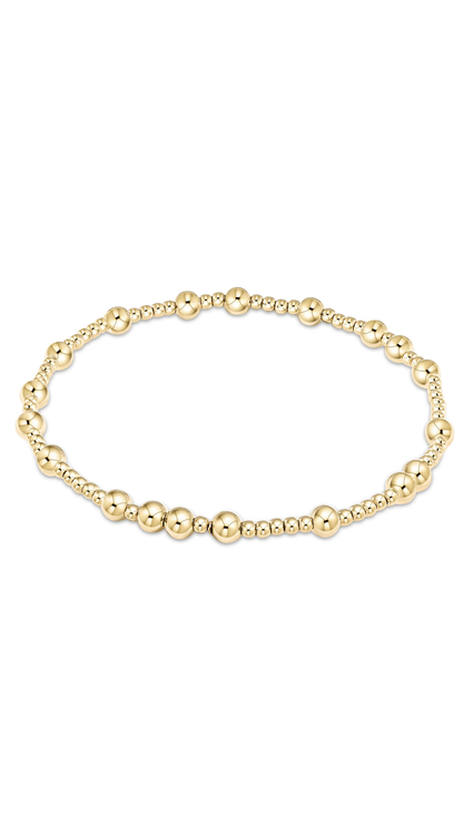 A delicate gold beaded bracelet with alternating large polished round beads and smaller textured beads, displayed on a clean white background.