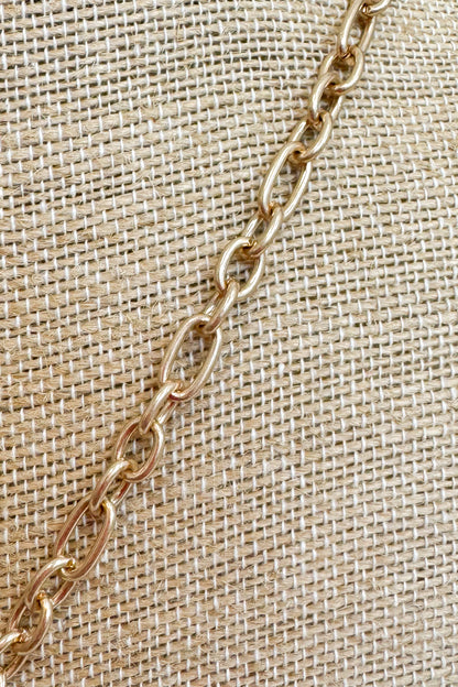Gold-tone delicate chain necklace featuring a fine textured chain shown on a beige jewelry bust