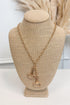 Gold-tone delicate chain necklace featuring two horsebit pendants, shown on a beige jewelry bust