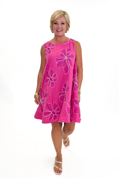 Front view of woman wearing Swagger Boutique’s Hot Pink Floral Embroidered Mini Dress with heels against white studio background.