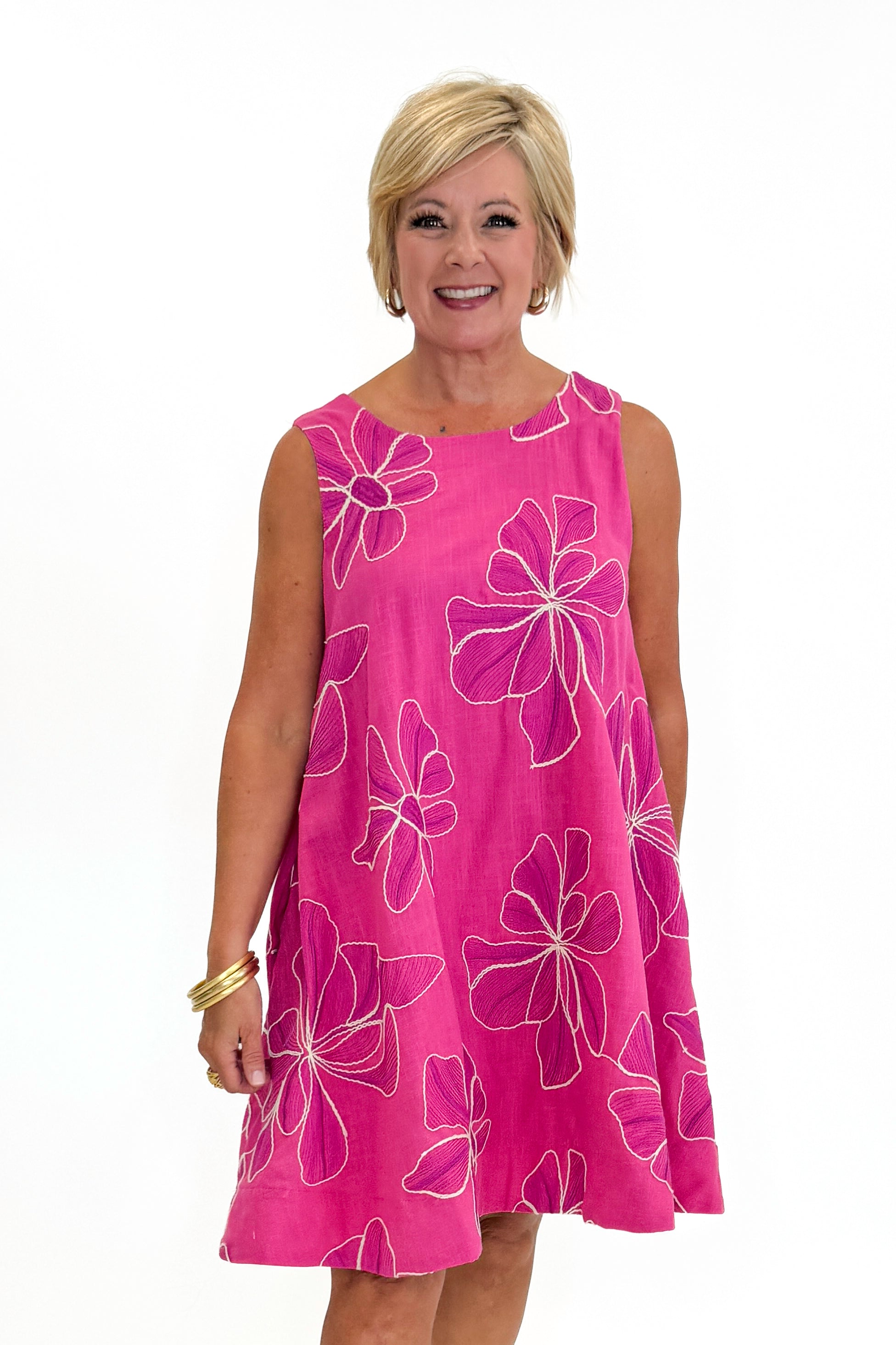 Front view of woman wearing Swagger Boutique’s Hot Pink Floral Embroidered Mini Dress with heels against white studio background.
