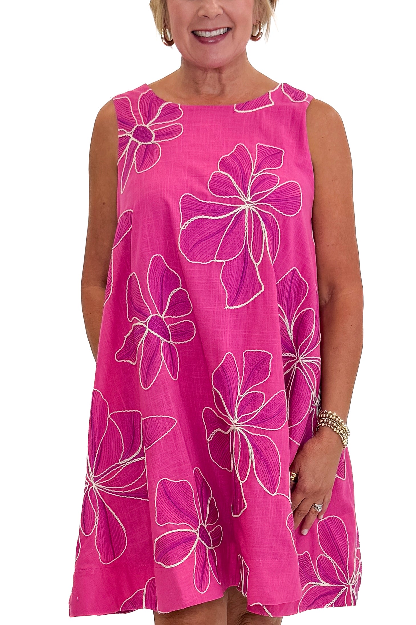Front detail view of woman wearing Swagger Boutique’s Hot Pink Floral Embroidered Mini Dress with heels against white studio background.