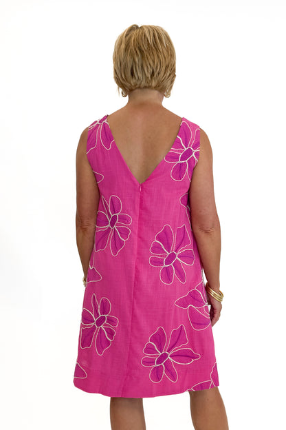 Back view of woman wearing Swagger Boutique’s Hot Pink Floral Embroidered Mini Dress with heels against white studio background.