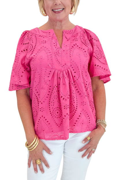 Front detail view of woman wearing Swagger Boutique’s Hot Pink Flutter Sleeve Eyelet Top with jeans against white studio background.