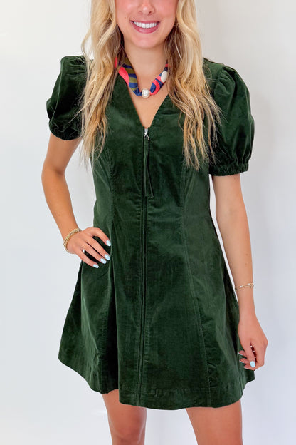 Front detail view of woman wearing Swagger Boutique’s Hunter Green Corduroy Mini Dress by Entro with boots against white studio background.