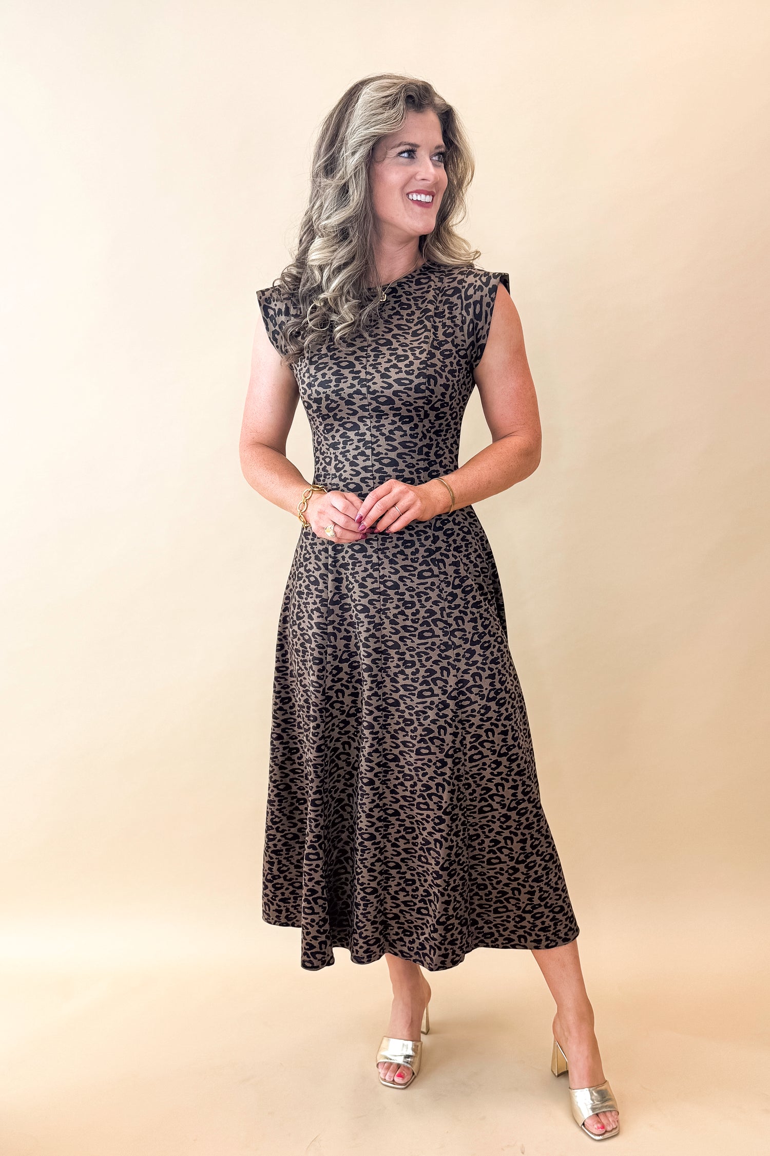 Front view of woman wearing Leopard Suede Midi Dress against tan studio background.