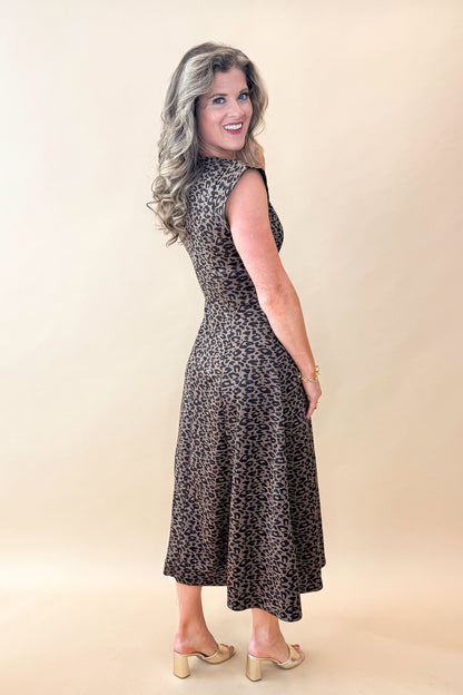 Side view of woman wearing Leopard Suede Midi Dress against tan studio background.