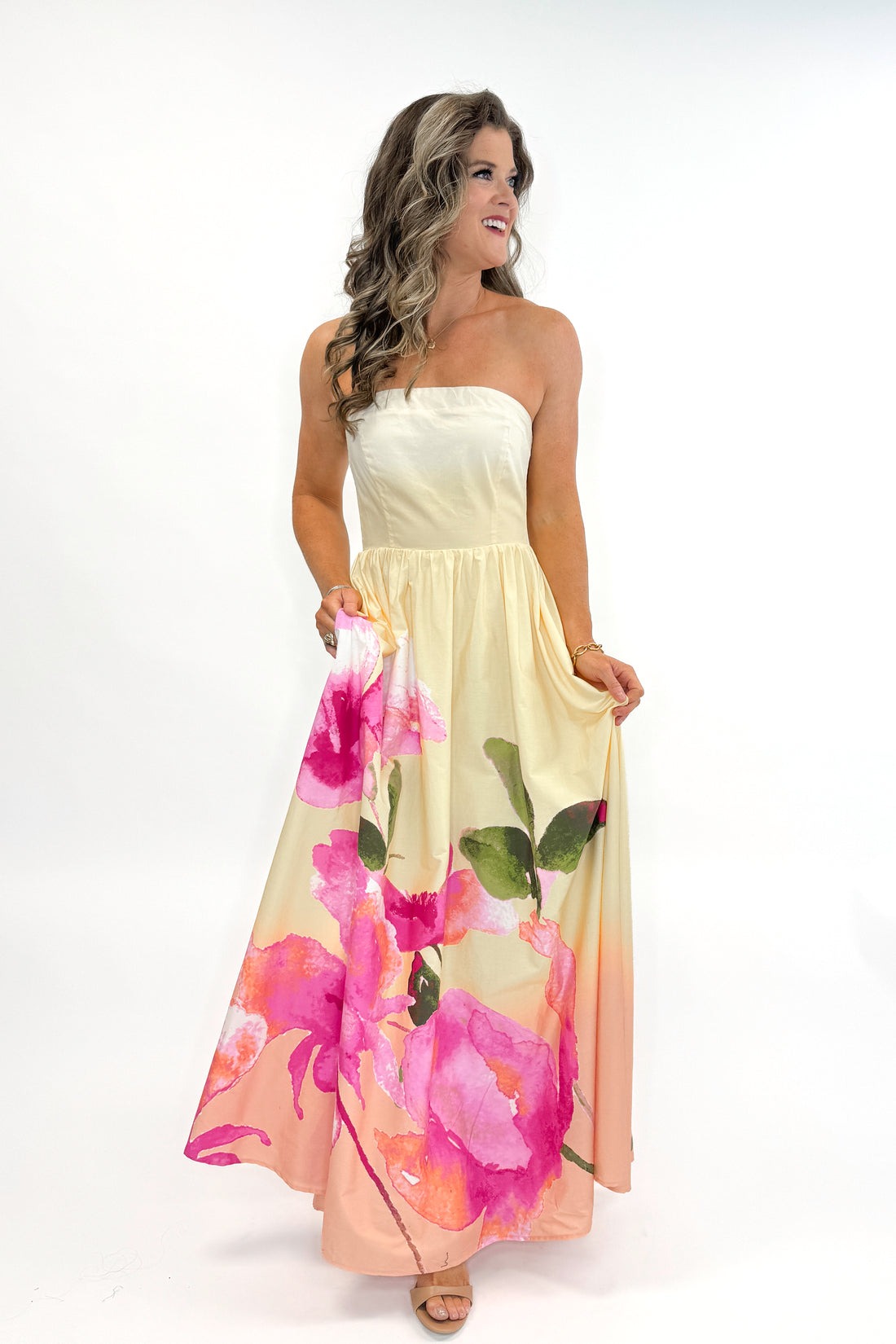 Front view of woman wearing Yellow &amp; Pink Floral Print Strapless Maxi Dress against white studio background.