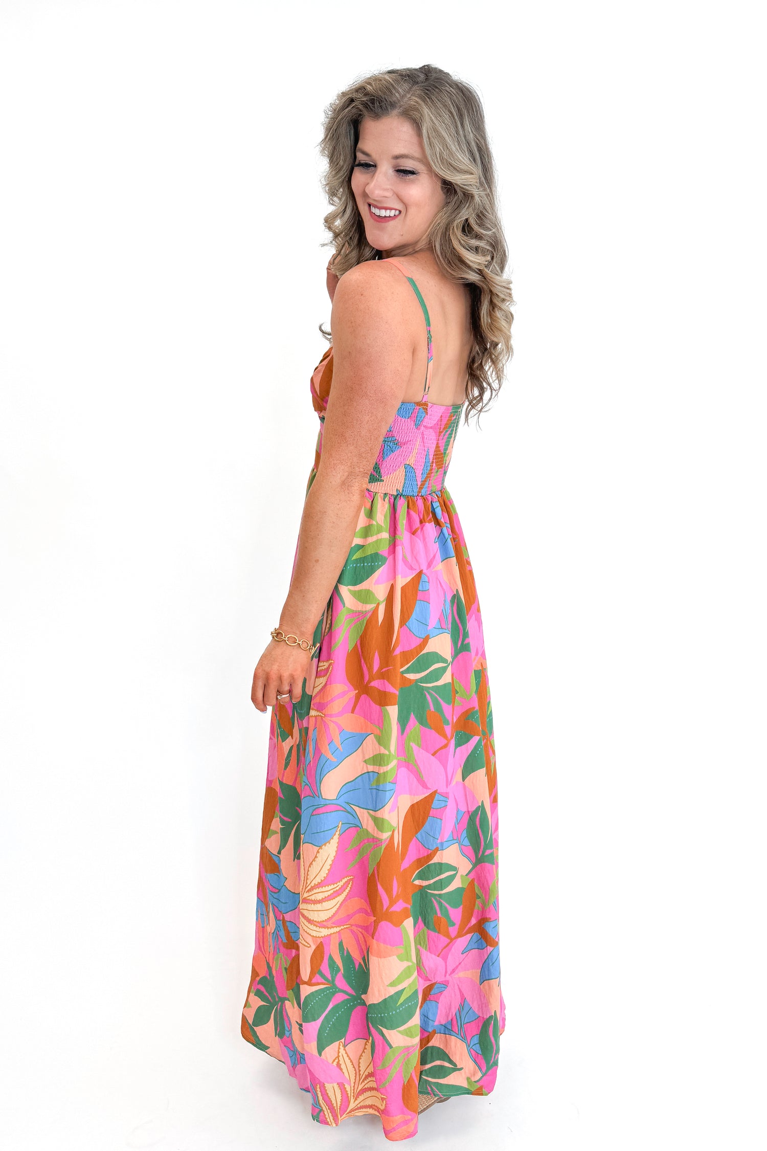 Side view of woman wearing Multi Tropical Printed Maxi Dress against white studio background.