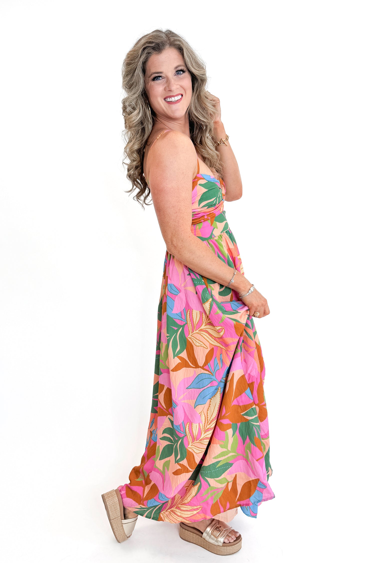 Side view of woman wearing Multi Tropical Printed Maxi Dress against white studio background.