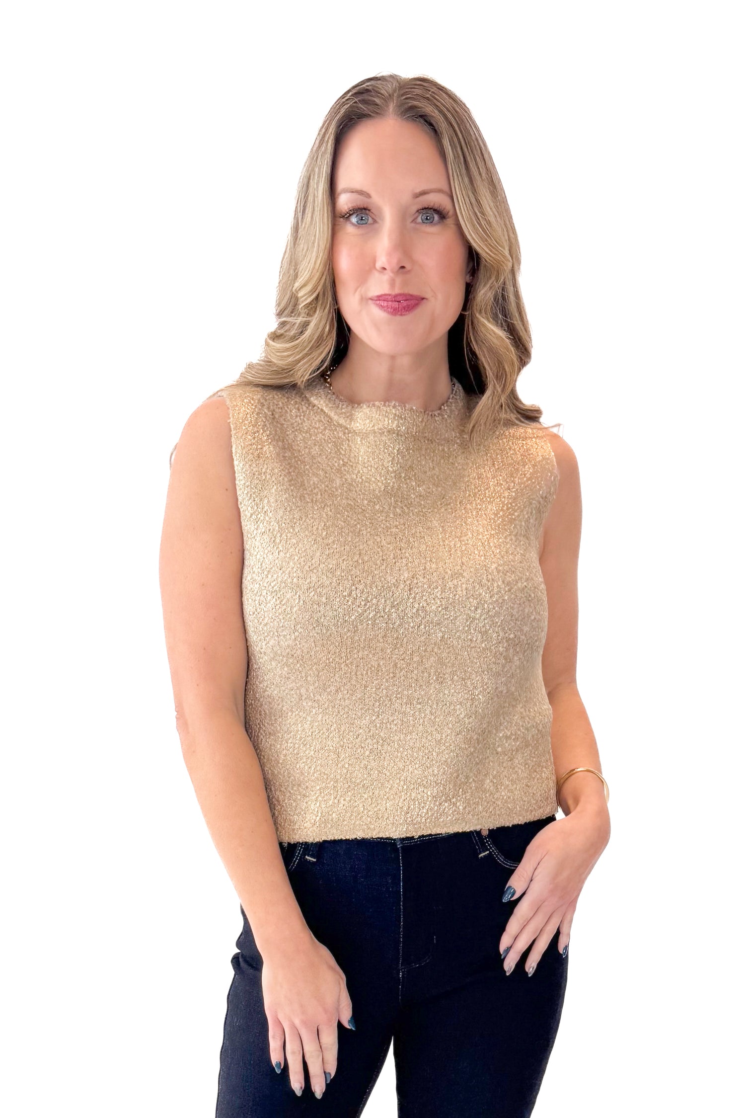 Front view of woman wearing Gold Sleeveless Sweater with jeans against white studio background.