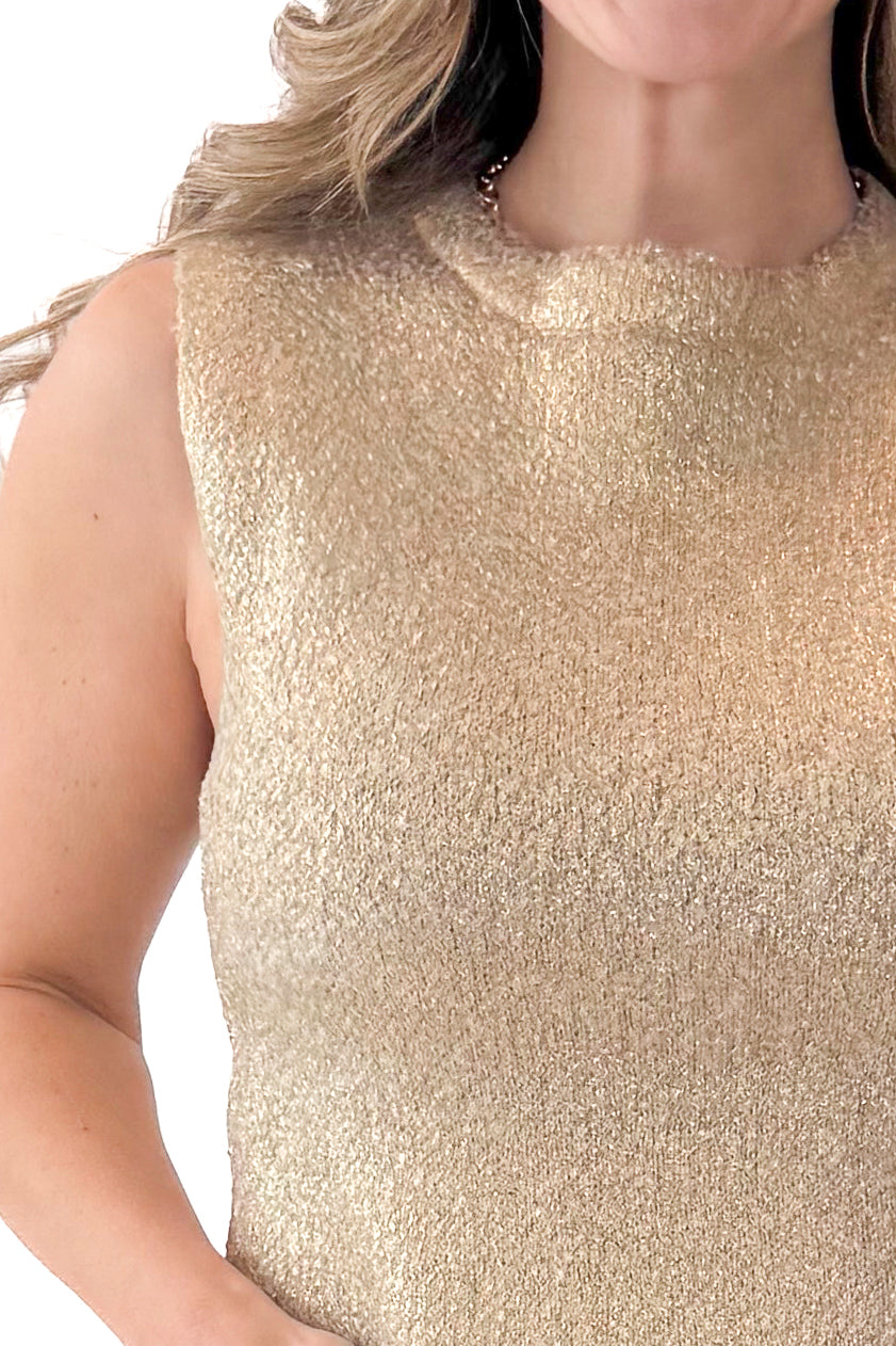Front detail view of woman wearing Gold Sleeveless Sweater with jeans against white studio background.