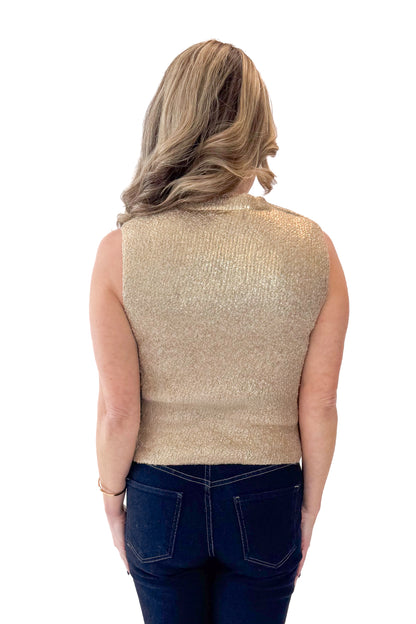 Back view of woman wearing Gold Sleeveless Sweater with jeans against white studio background.