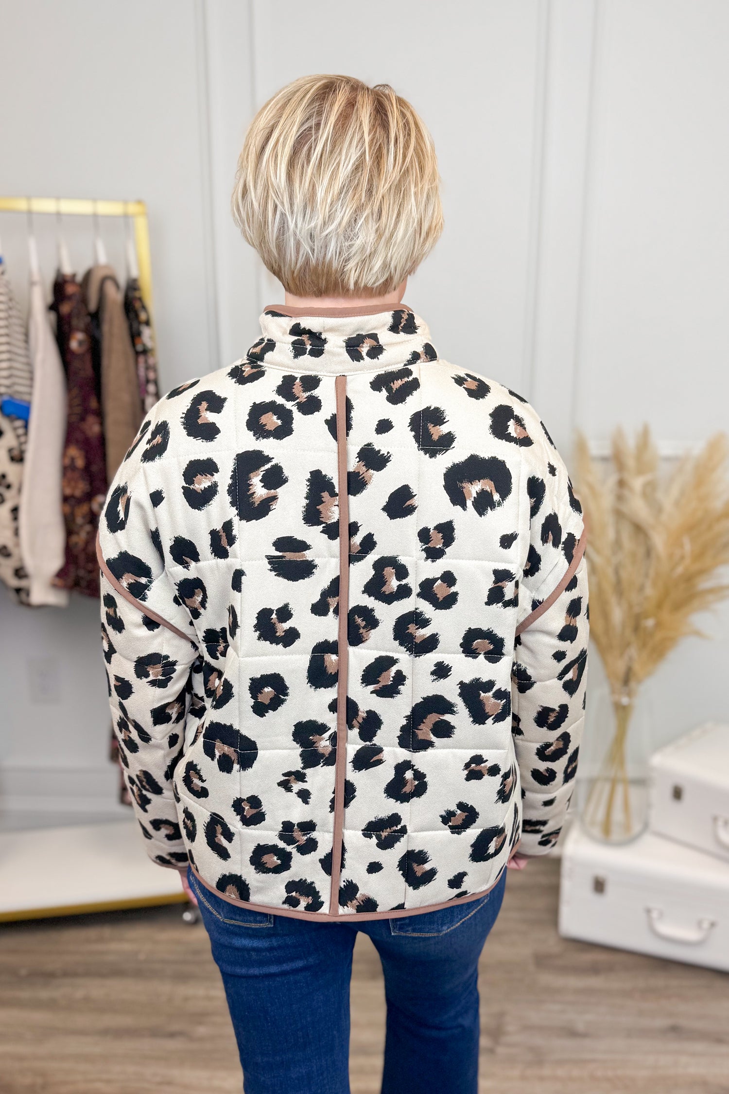 Person wearing a leopard print jacket in a clothing store setting