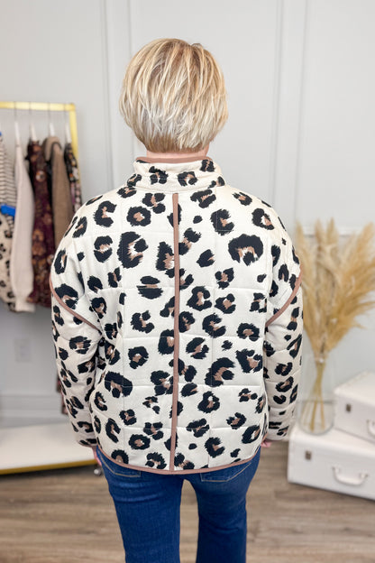 Person wearing a leopard print jacket in a clothing store setting