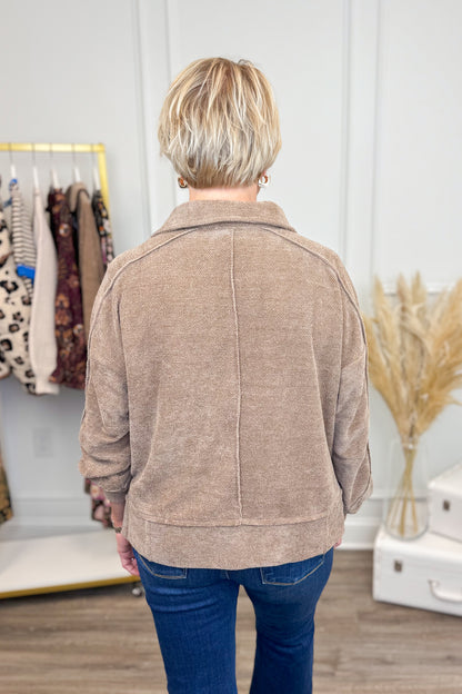Back view of Woman wearing Mocha Chenille Collared Top and jeans with decor in the background.