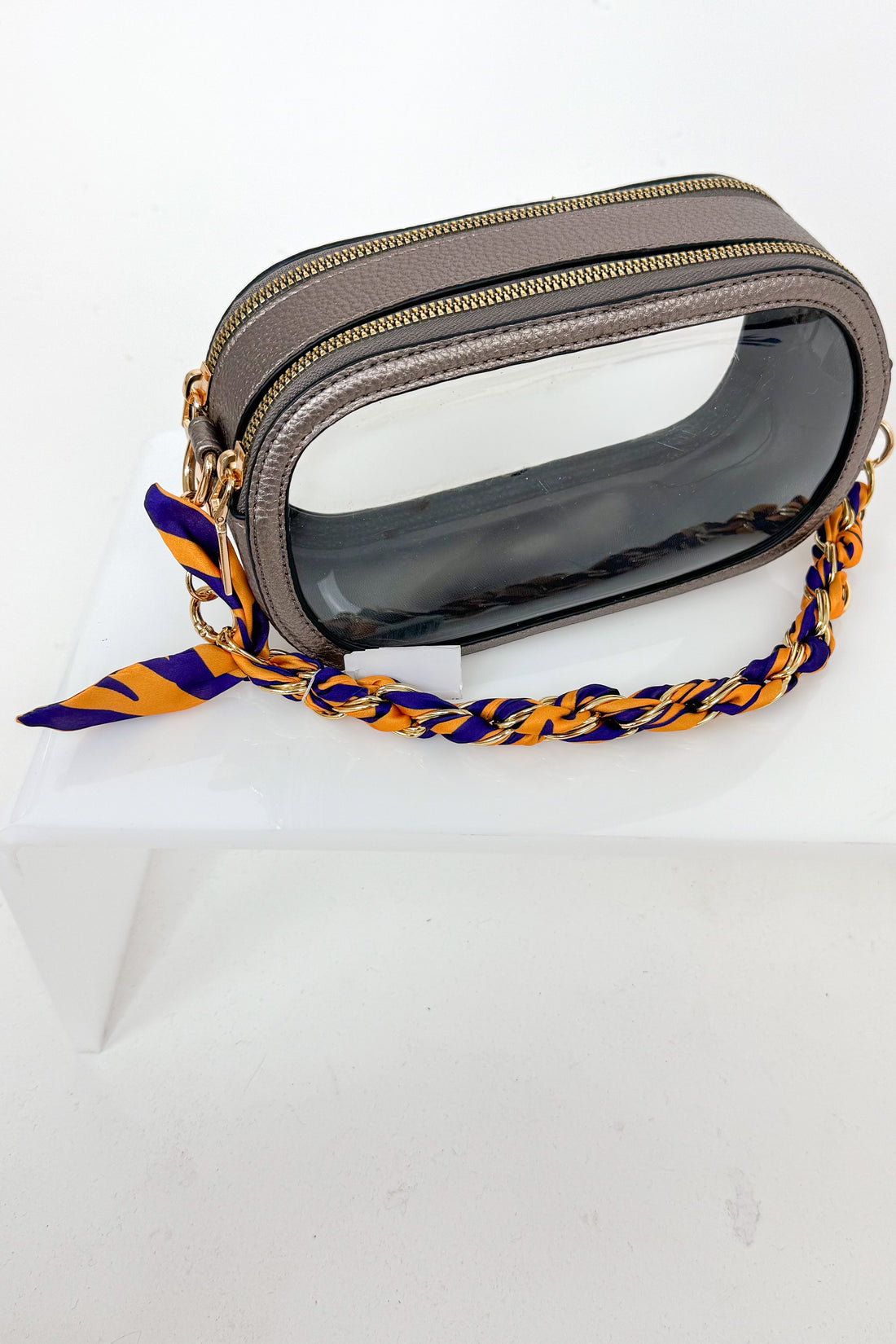 Gray clear bag with purple and yellow strap on a white background