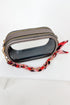 Small gray pouch with a red, black and white floral strap on a white background