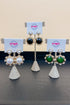 Three pairs of earrings on a stand with &
