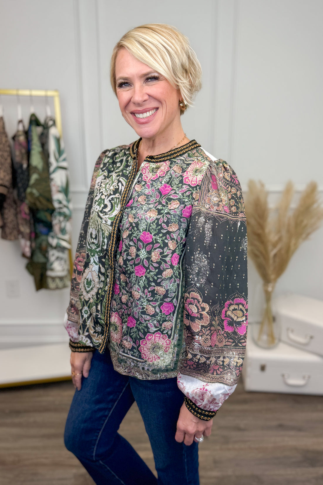 Woman wearing a floral patterned shirt in a clothing store setting