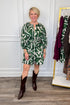 woman wearing green abstract printed tie waist dress with brown boots