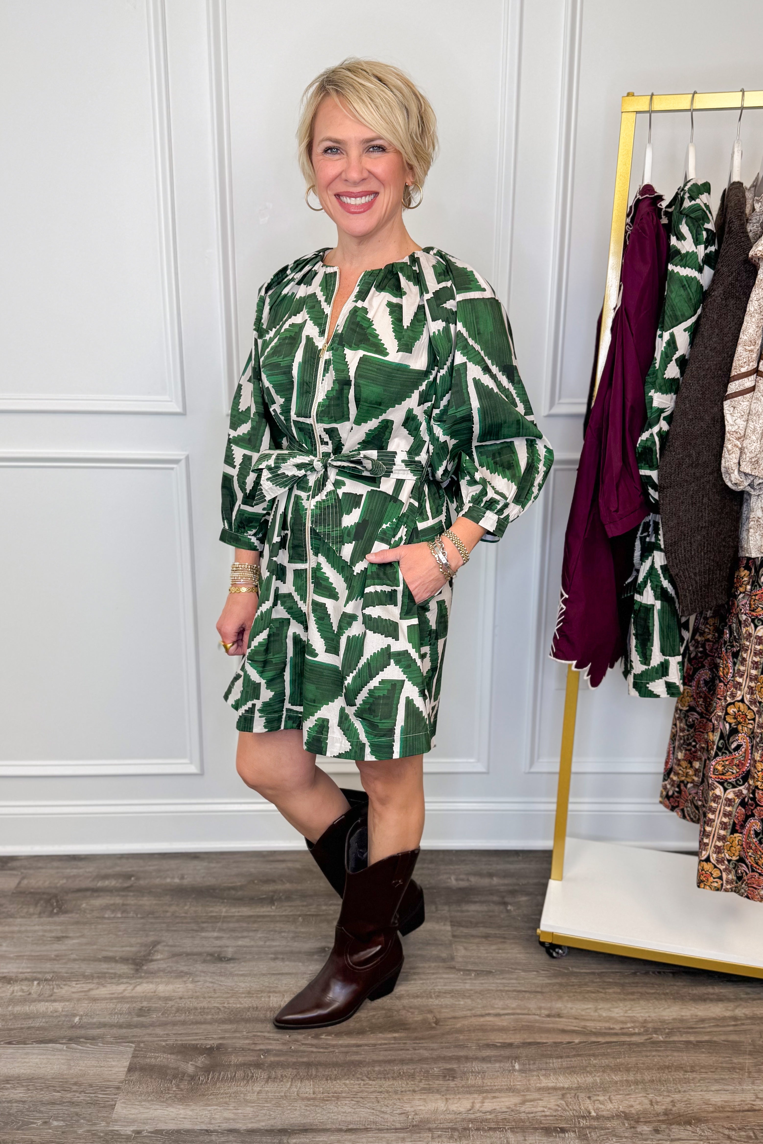 woman wearing green abstract printed tie waist dress with brown boots