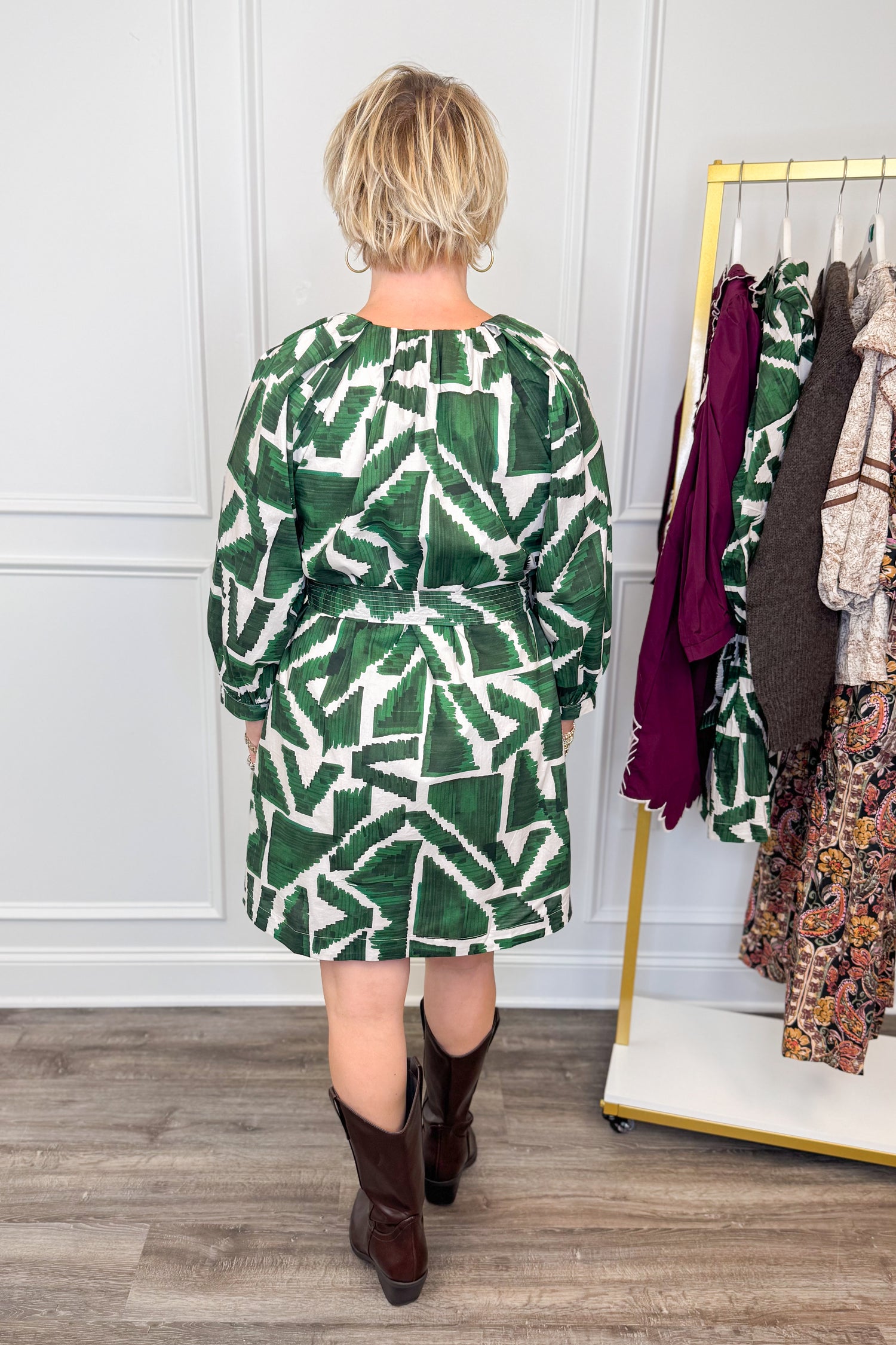 woman wearing green abstract printed tie waist dress with brown boots