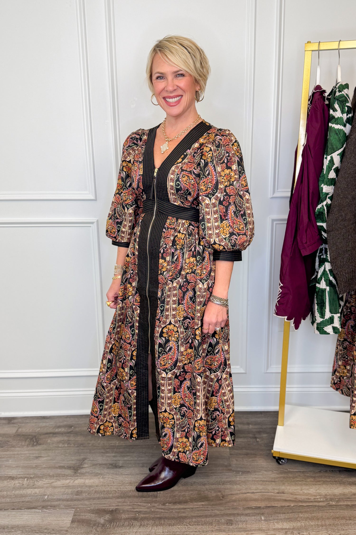 woman wearing multi printed midi dress with center zipper and burgundy boots