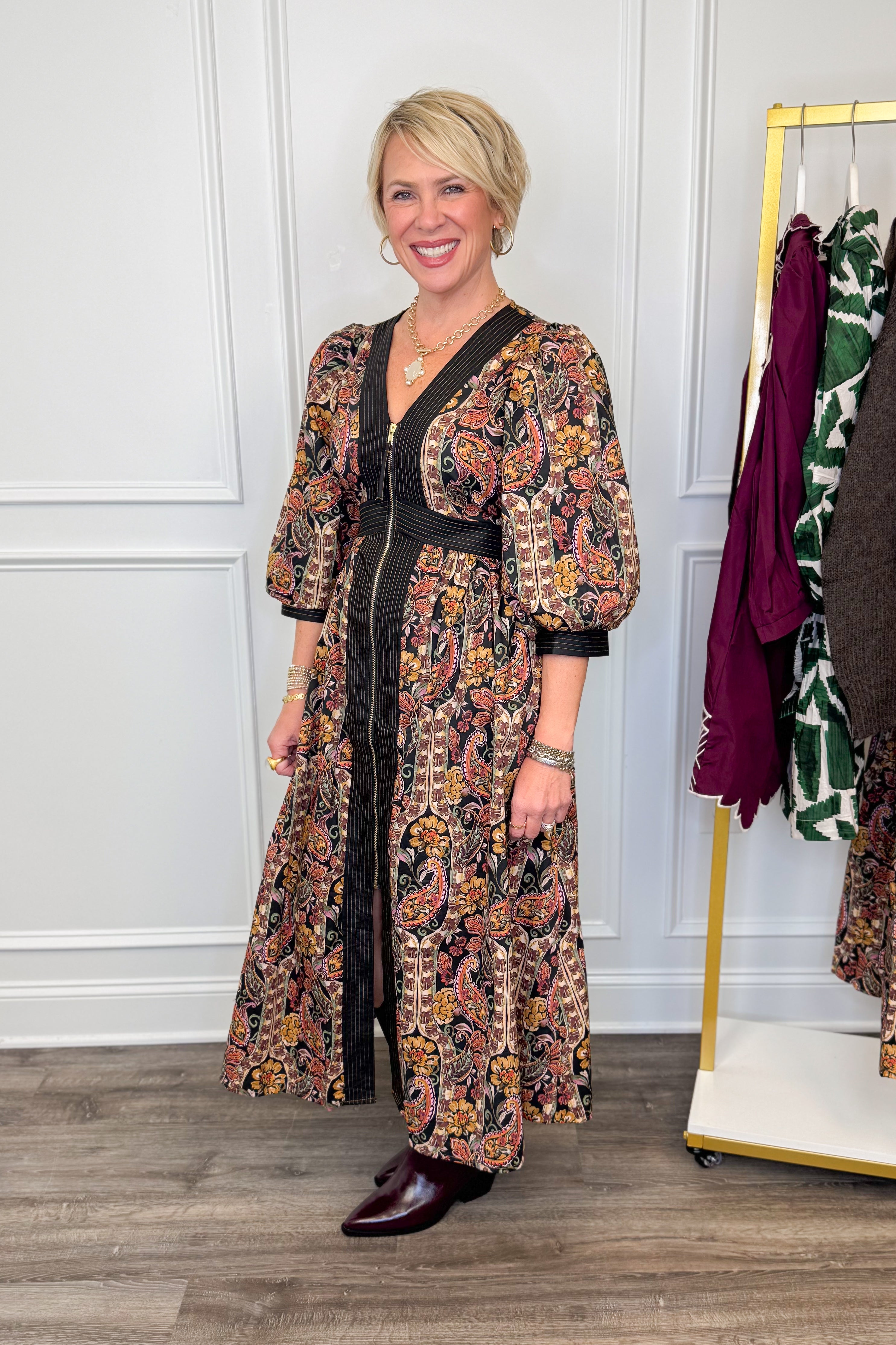 woman wearing multi printed midi dress with center zipper and burgundy boots