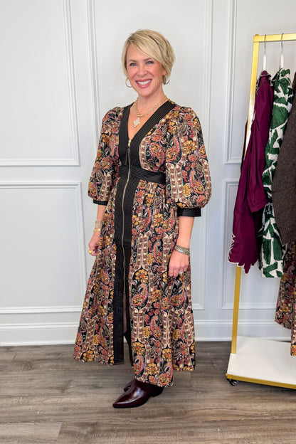 woman wearing multi printed midi dress with center zipper and burgundy boots