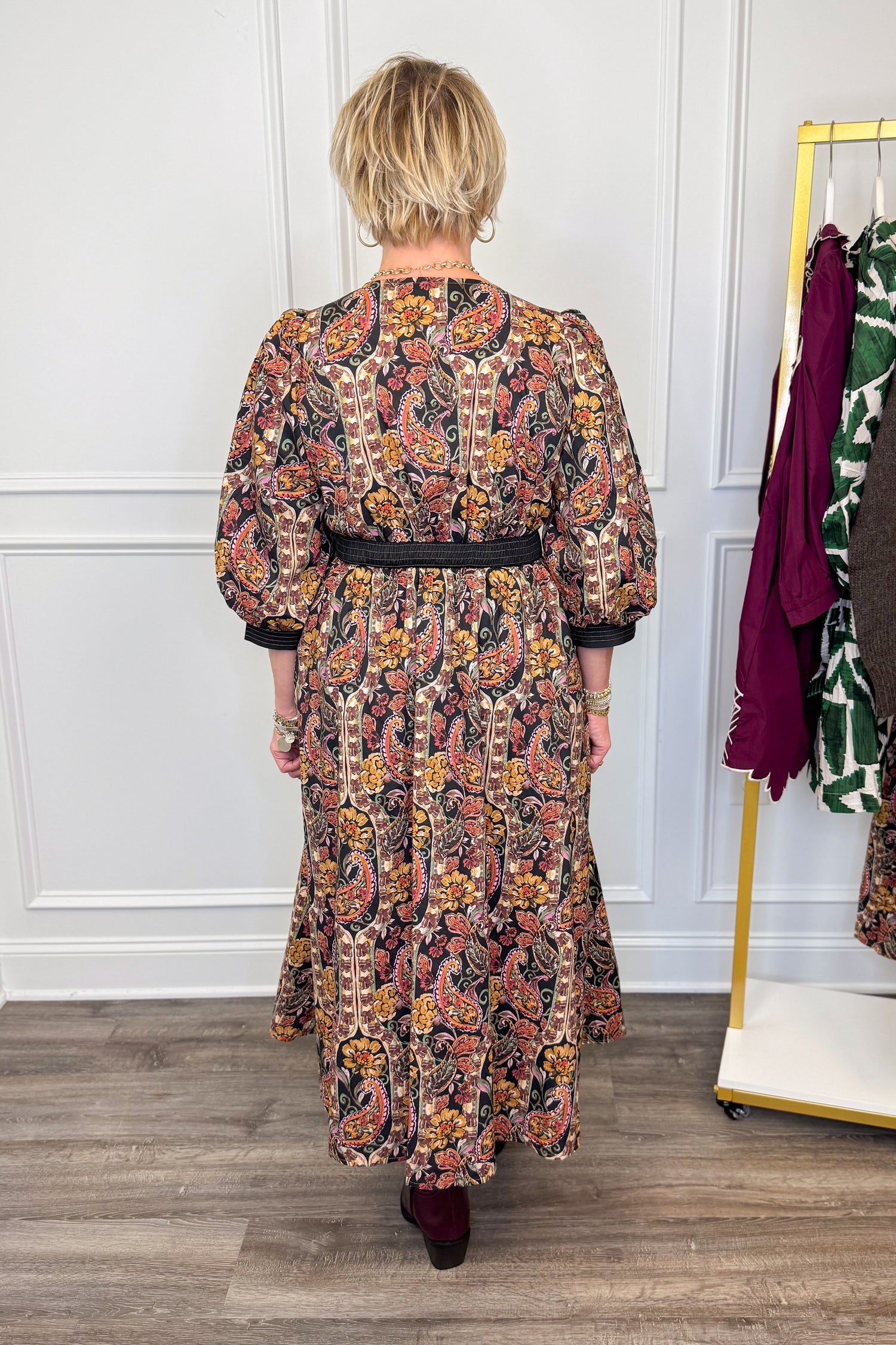 woman wearing multi printed midi dress with center zipper and burgundy boots