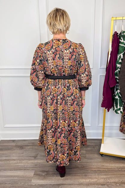 woman wearing multi printed midi dress with center zipper and burgundy boots