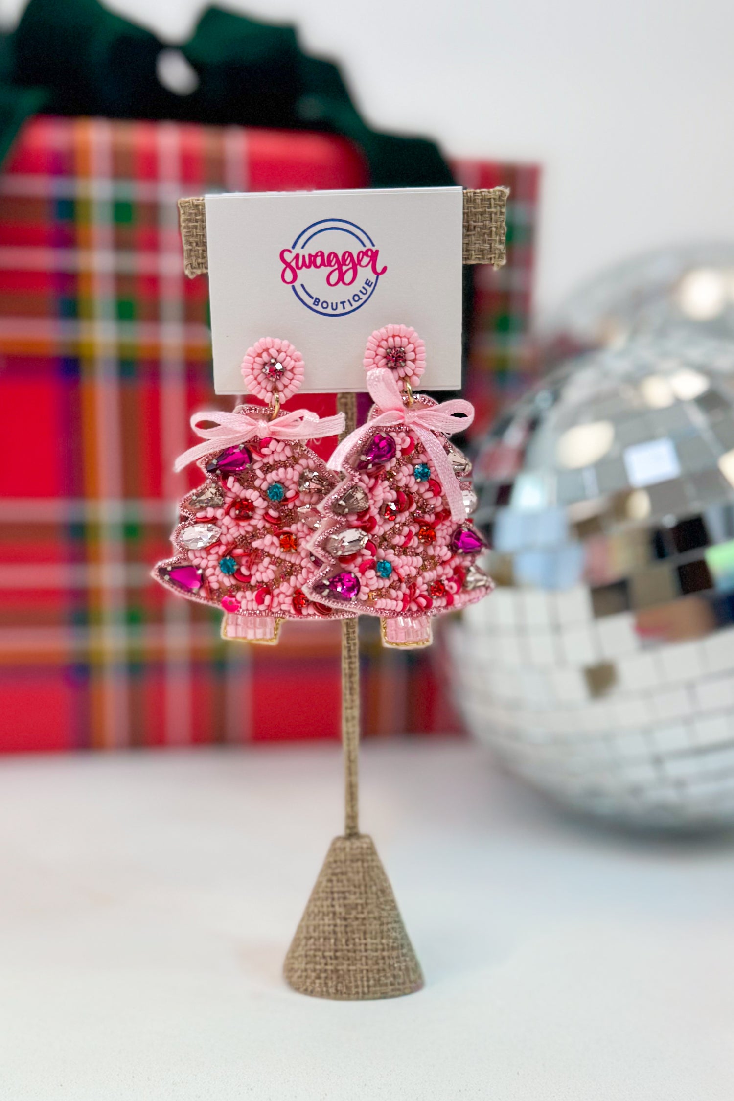 Pink beaded earrings on a stand with a &