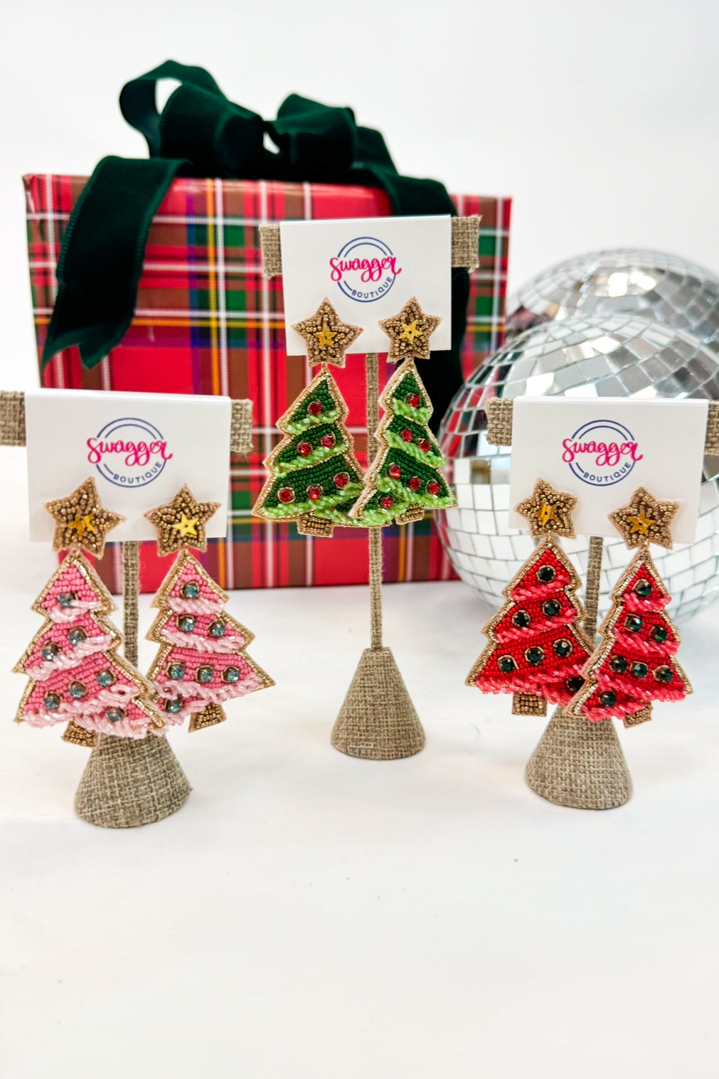 Christmas tree earrings with gift box and disco ball on a white background
