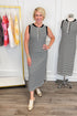 Woman wearing a black and white striped dress in a clothing store.