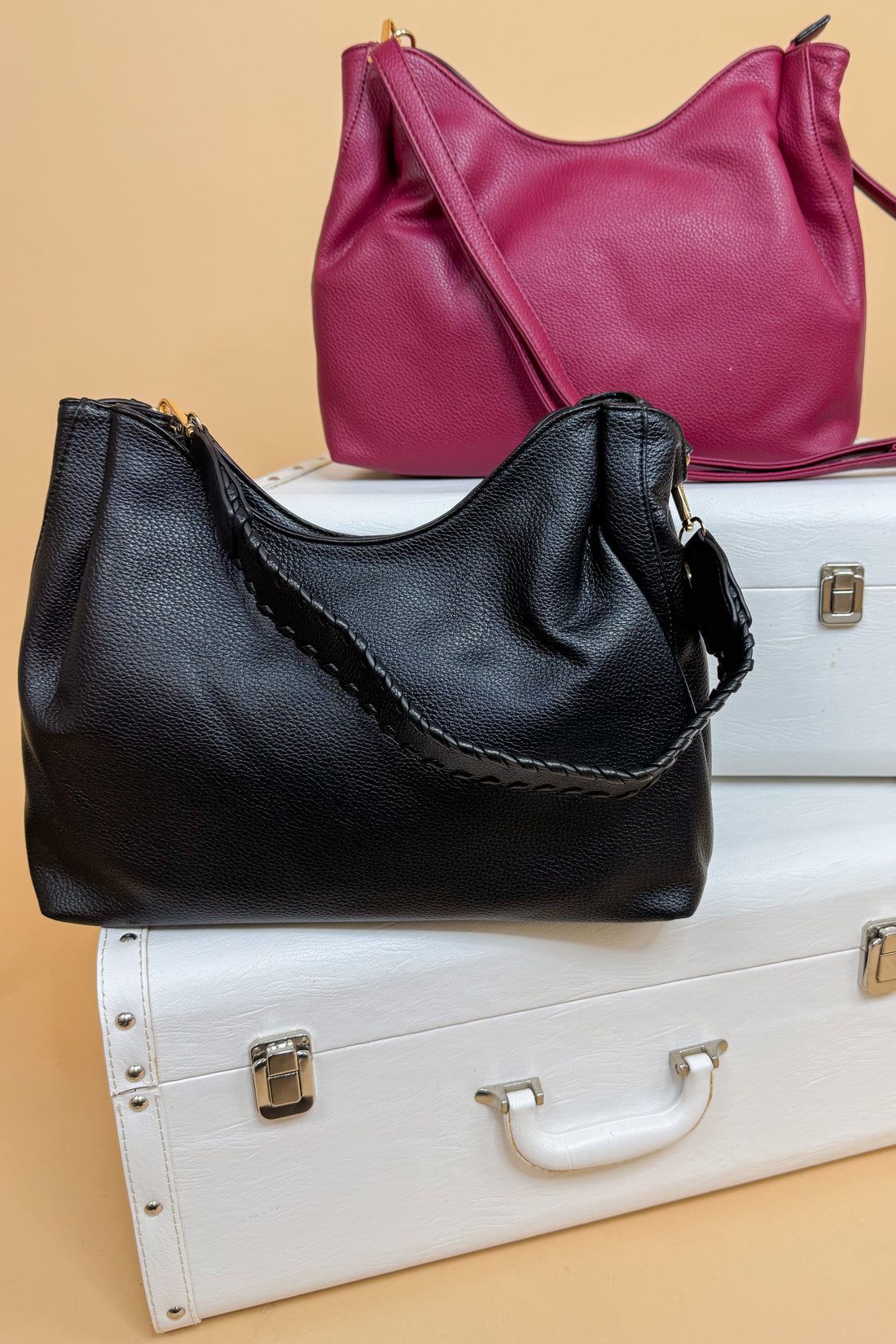 Black and pink handbags on a beige background