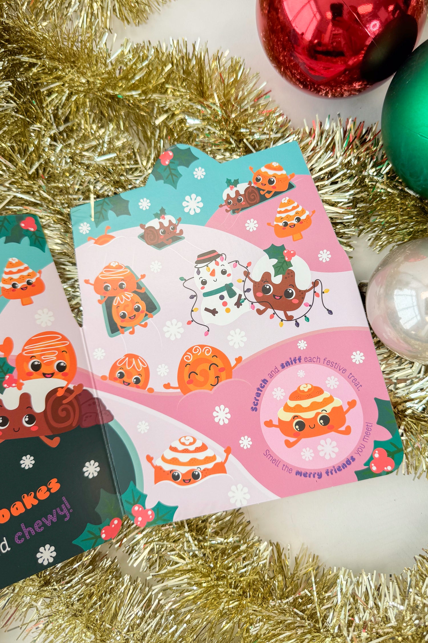 Gingerbread house-shaped scratch and sniff book with a heart label on a white background