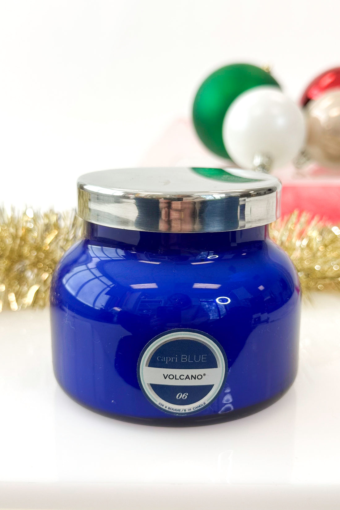 Blue candle jar with silver lid on a white background