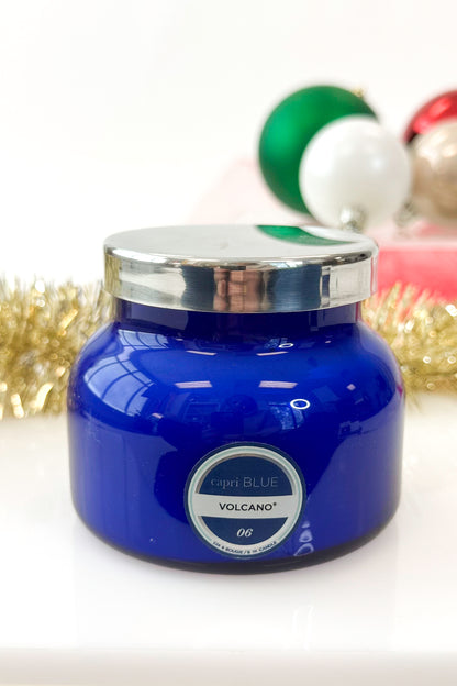 Blue candle jar with silver lid on a white background