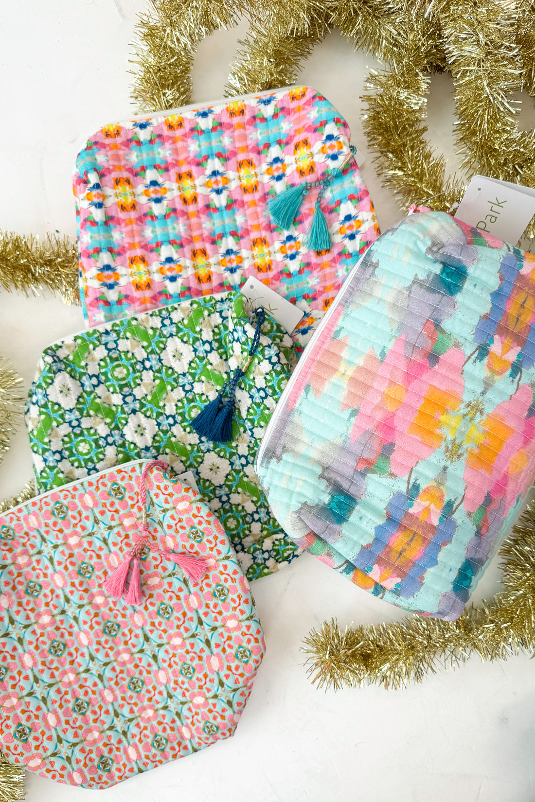 Collection of colorful fabric bags with tassels on a white background