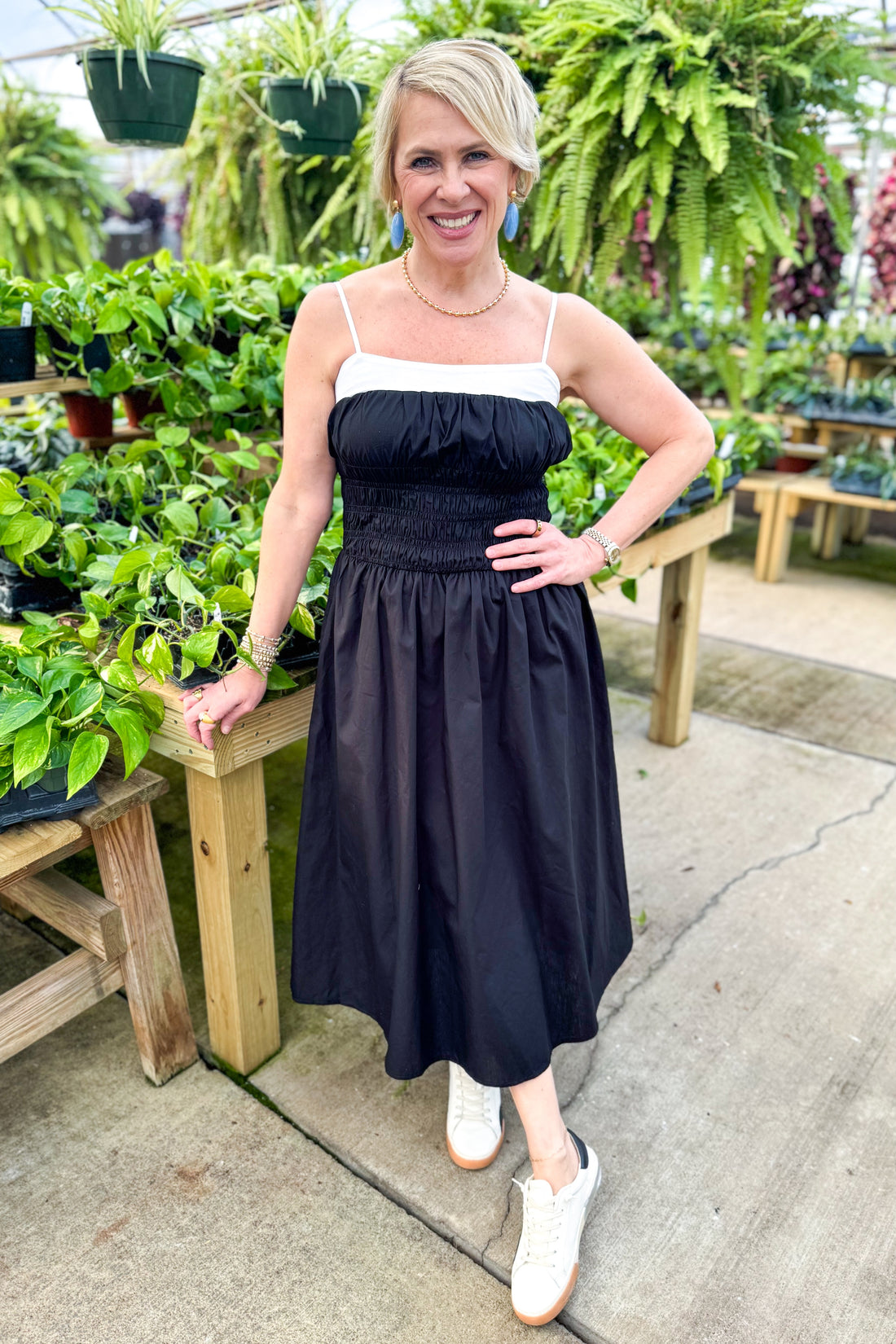 Front view of woman wearing Black With White Color Block Smocked Midi Dress at a garden center.