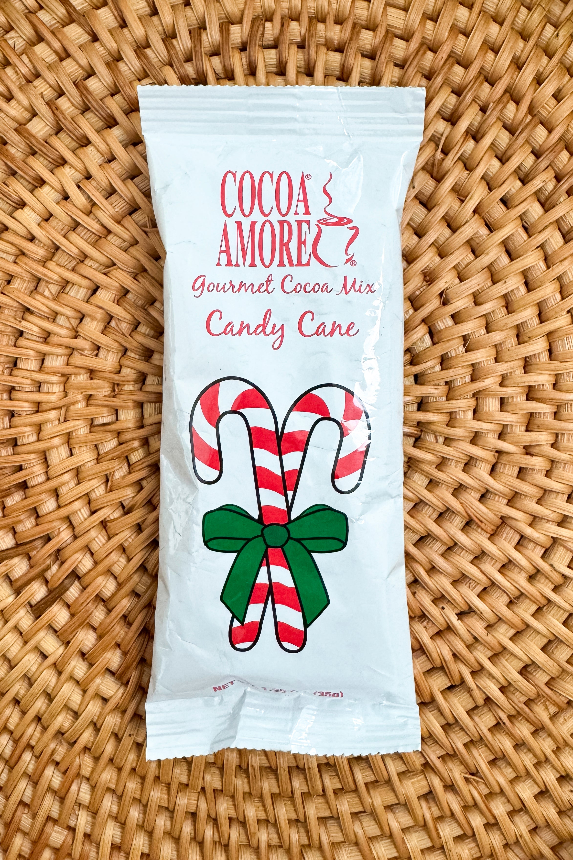 Cocoa Amore Gourmet Cocoa Mix Candy Cane packaging on a patterned background