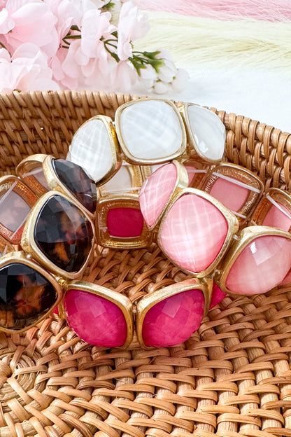 Colorful bracelets with gold accents on a patterned surface