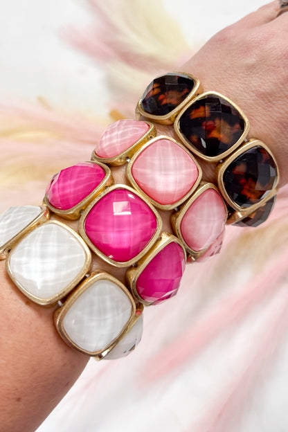 Colorful bracelets with gold accents on a white background