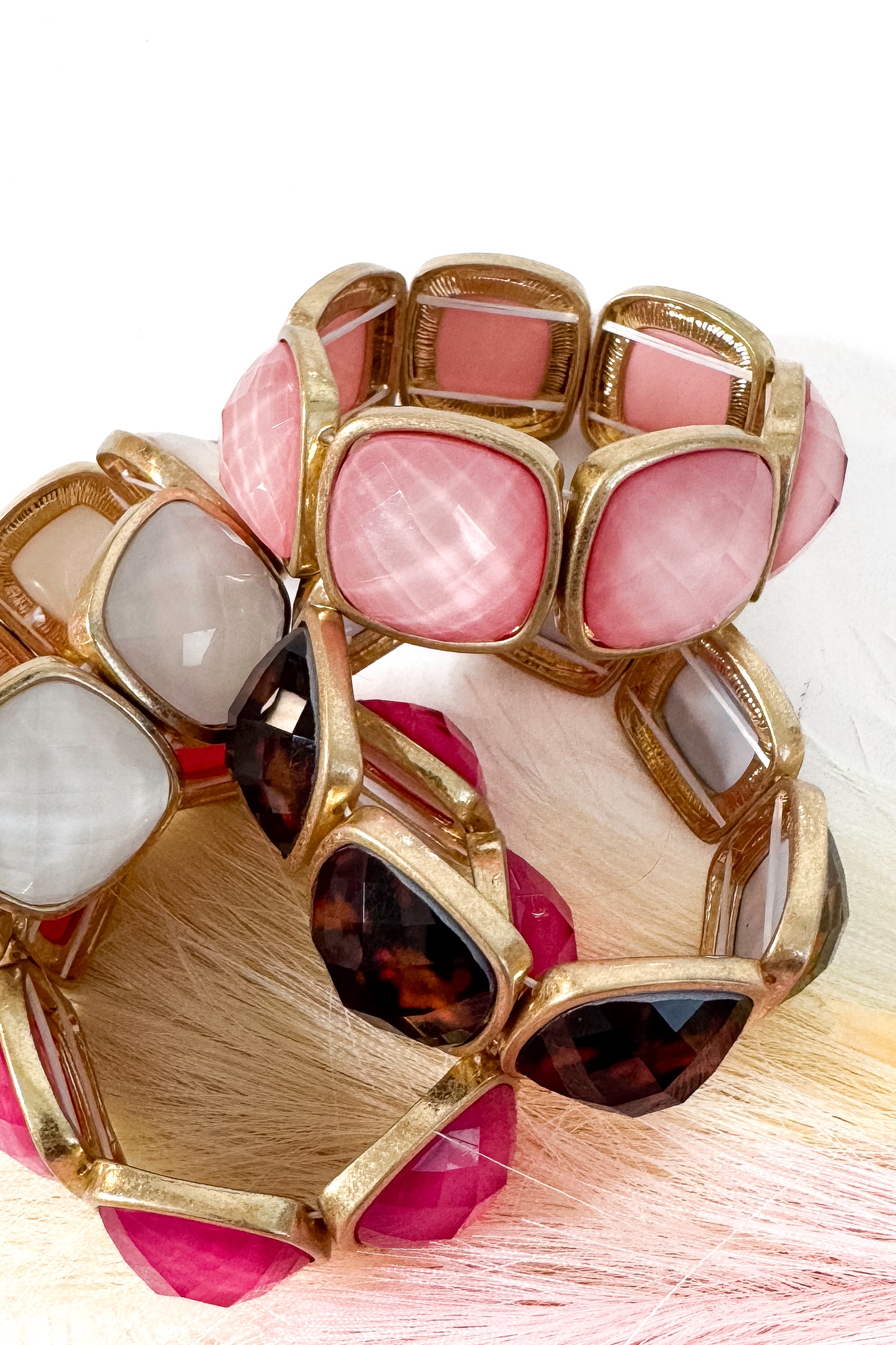 Colorful bracelets with gold accents on a white background