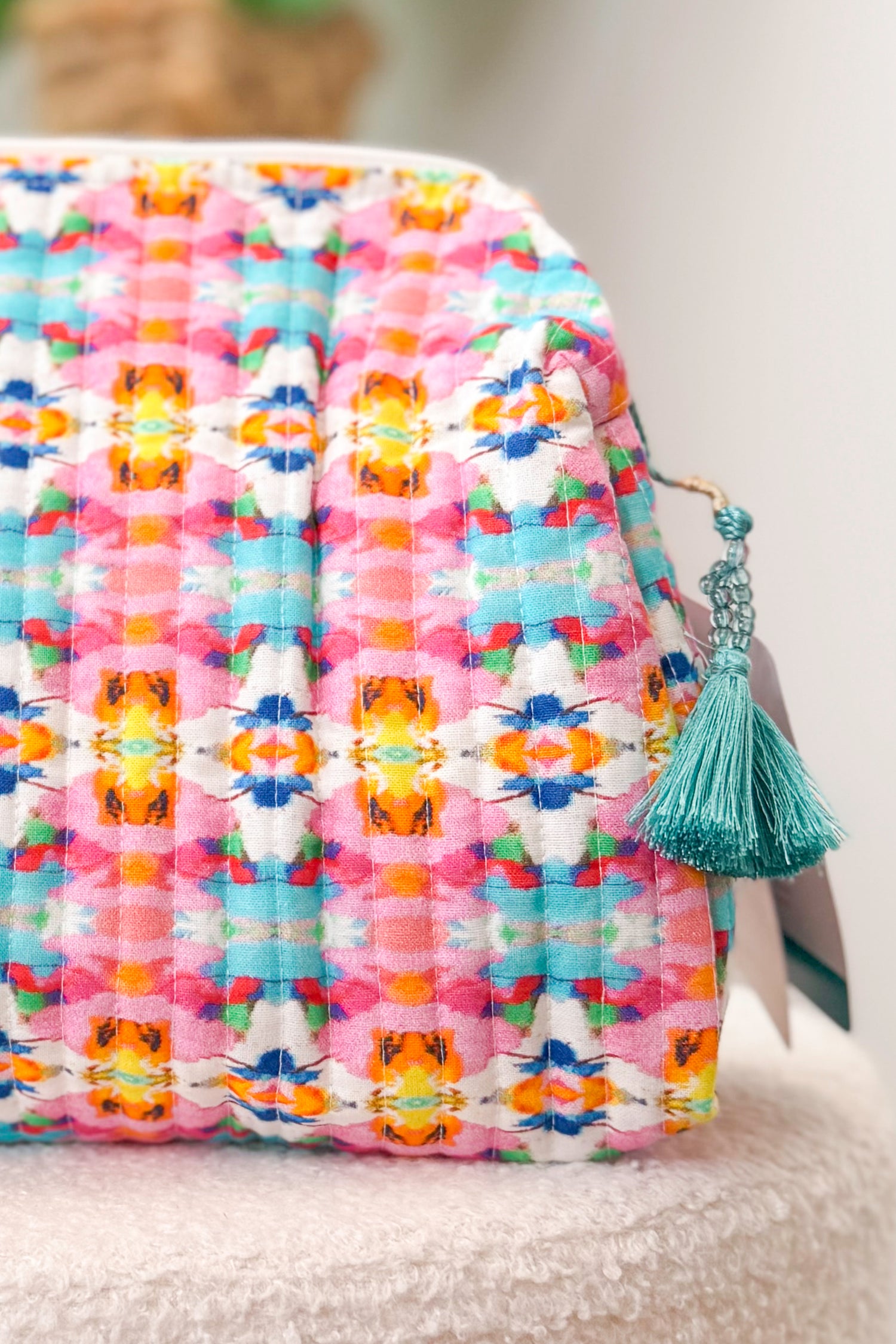 Colorful quilt with a tassel on a neutral background