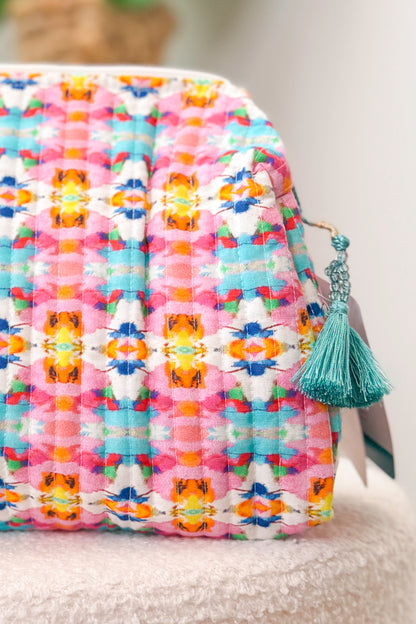 Colorful quilt with a tassel on a neutral background